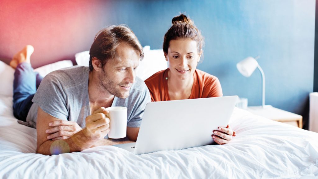 Ein Paar schaut gemeinsam auf einem Laptop ein Onlinehaushaltsbuch an.